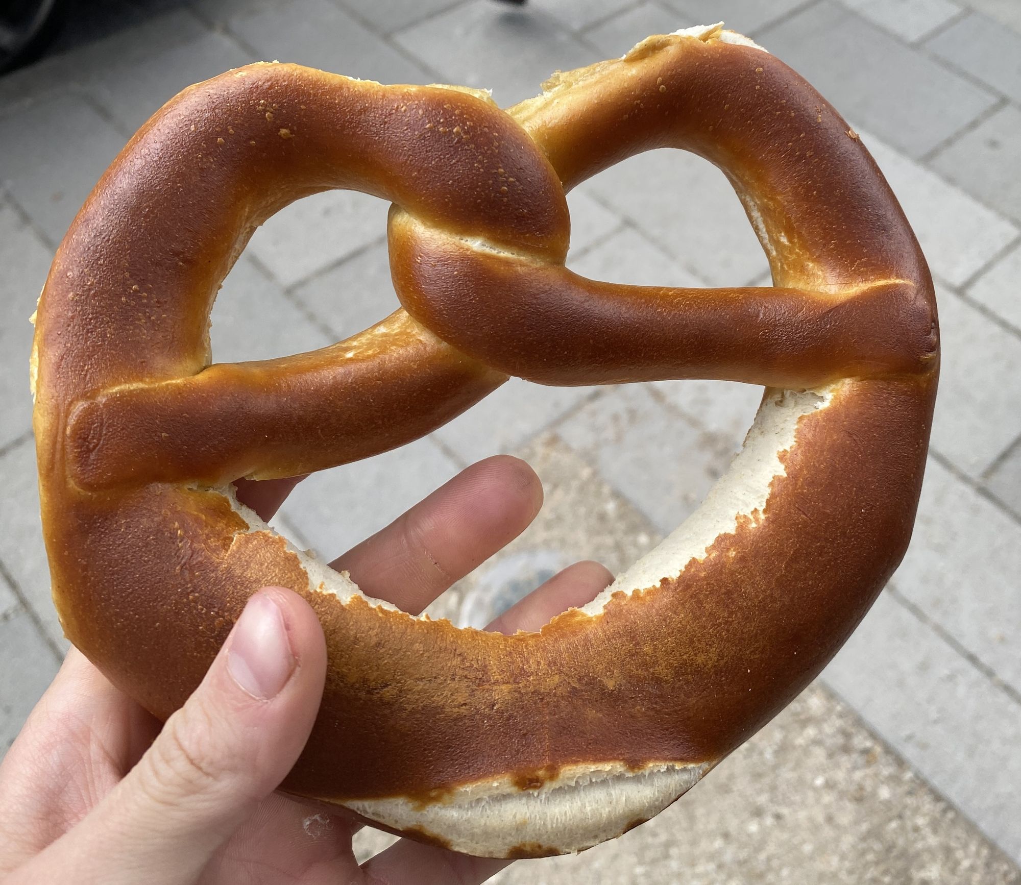 Someone holding a pretzel from Schäfer Dein Bäcker in the street