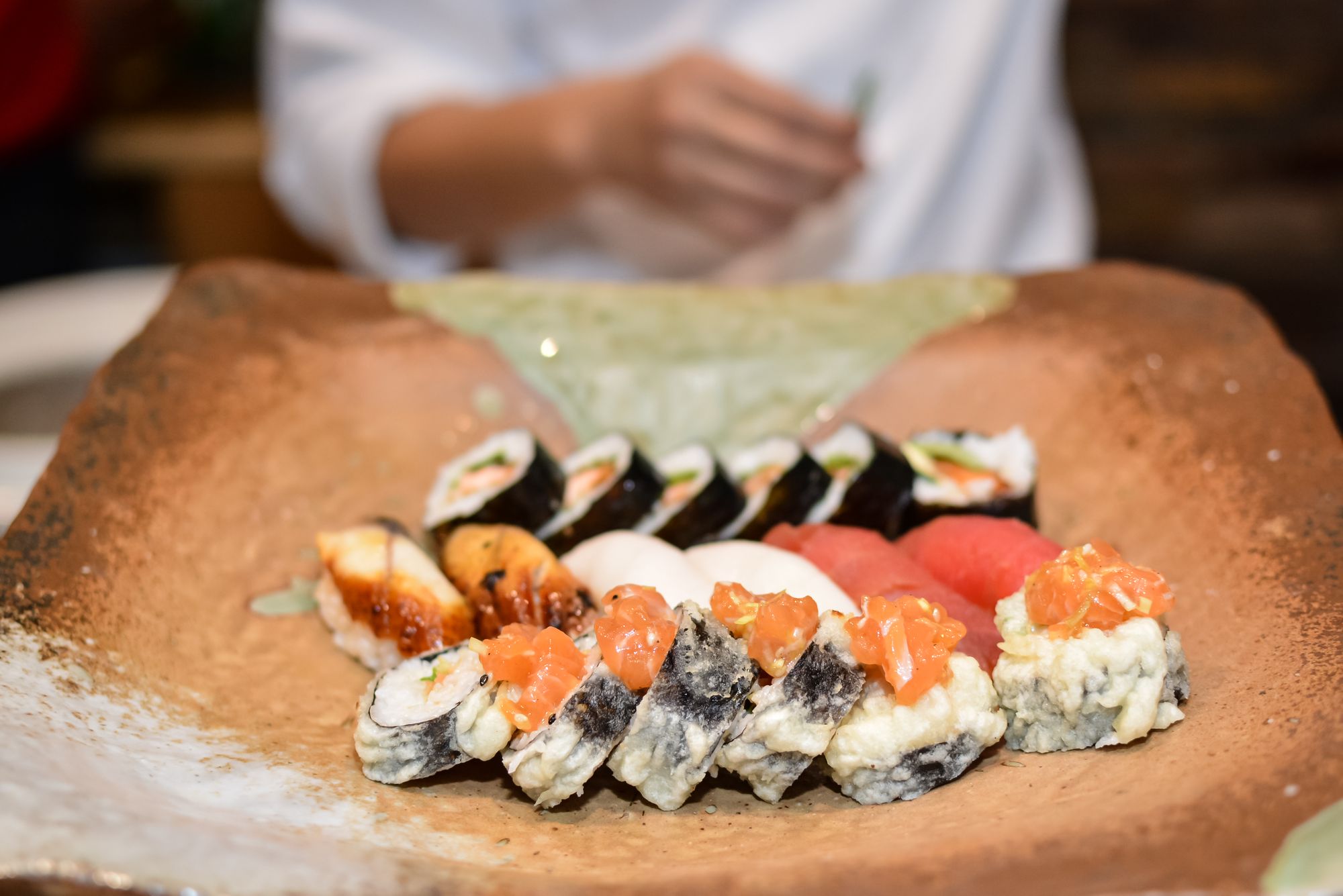 chef arranging sushi rolls on a plate