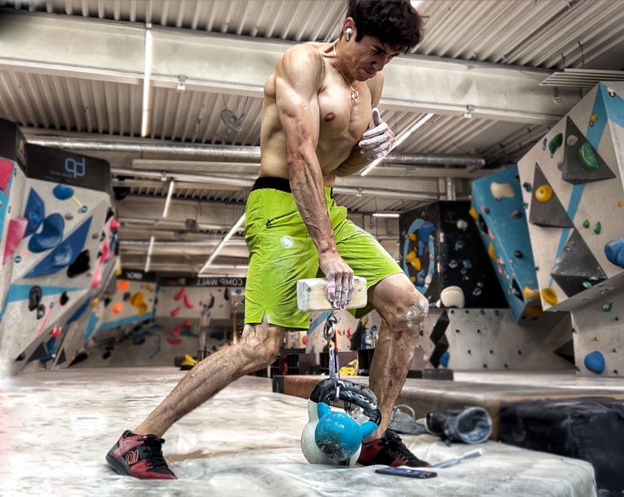 Man holding a pinch block at a climbing gym