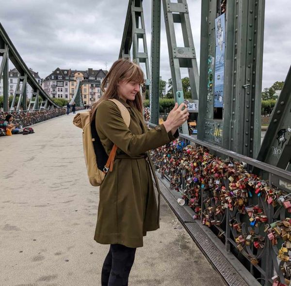 A woman taking a photo on a bridge in Frankfurt Am Main